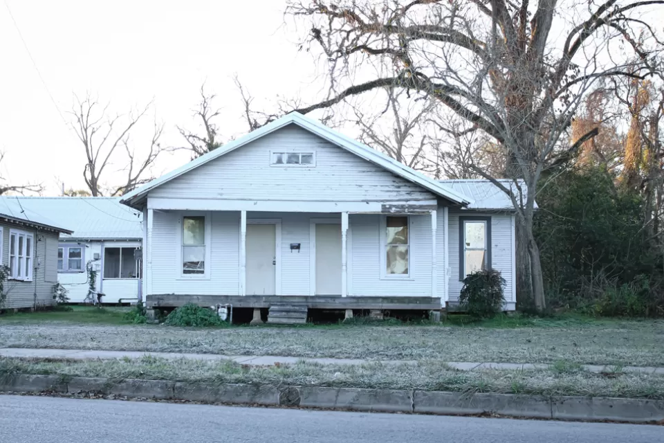 Dilapidated vacant wood slat house painted white in Louisiana